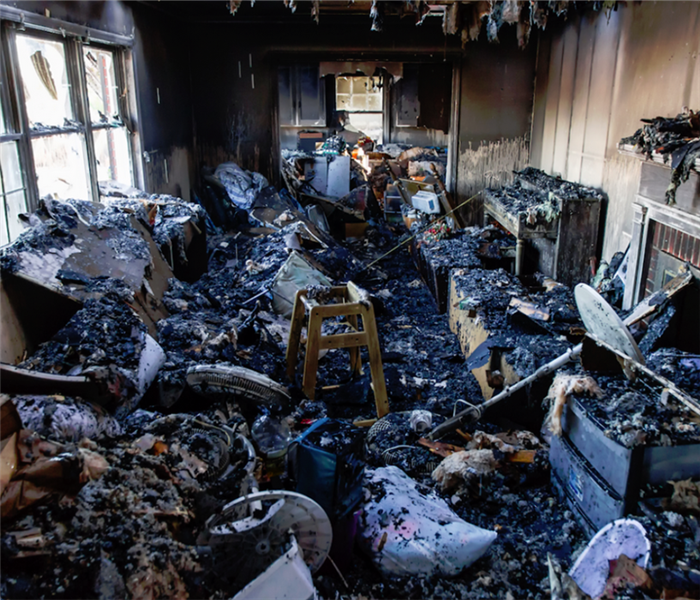 a fire damaged living room with soot and debris everywhere