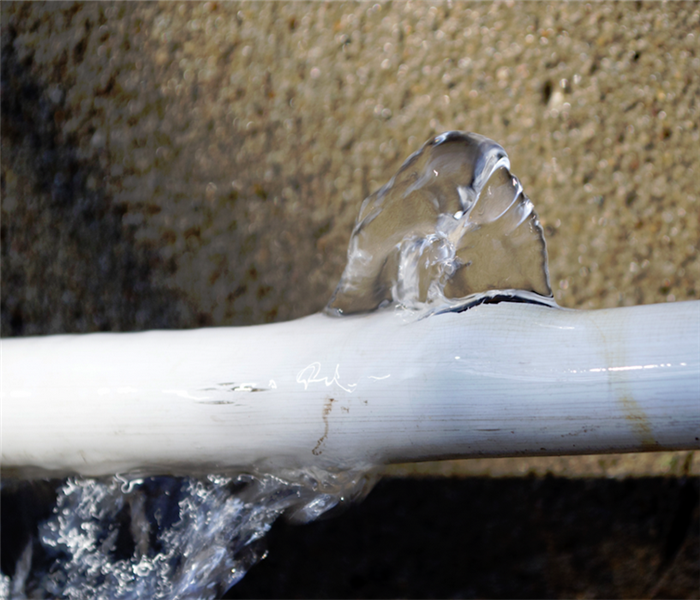 a broken white pipe with water leaking from it