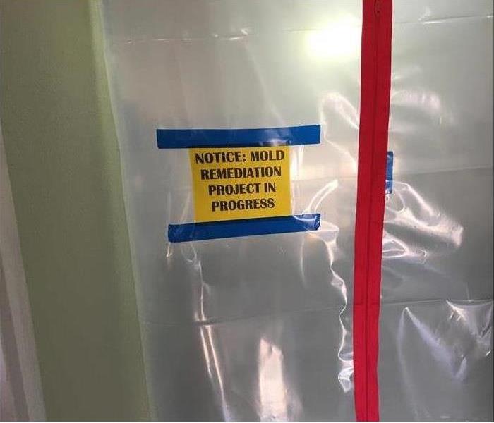 containment area with a yellow sign for mold remediation