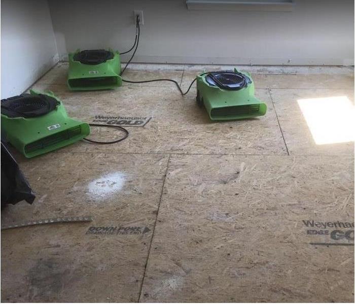SERVPRO equipment being used in water damaged room; flooring removed to plywood