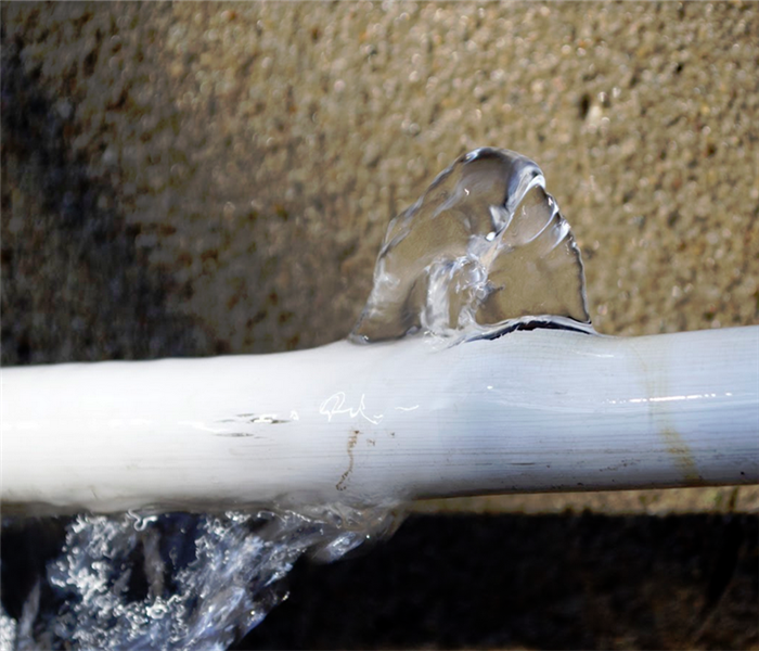 white pipe spewing water from broken spot